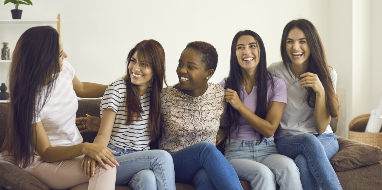 group-of-happy-multiracial-female-friends-sitting-on-sofa-telling-funny-jokes-and-laughing_t20_bzAX1g